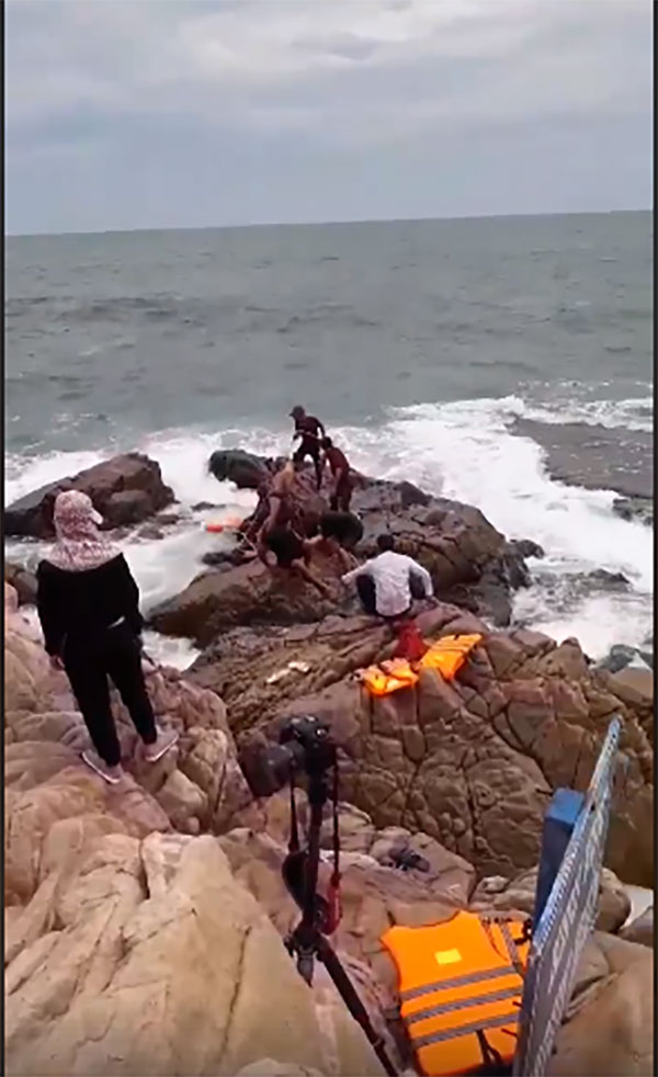 Ra mỏm đá trước biển chụp ảnh cưới, cô dâu bị sóng cuốn trôi, chú rể ngồi im nhìn người khác cứu