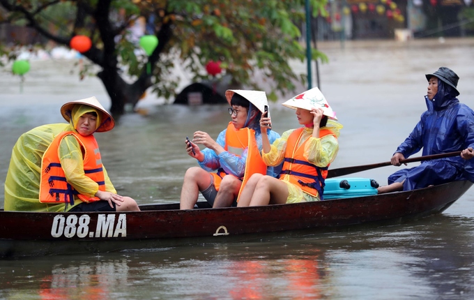 Khách nước ngoài bì bõm check-in giữa phố Hội ngập lũ