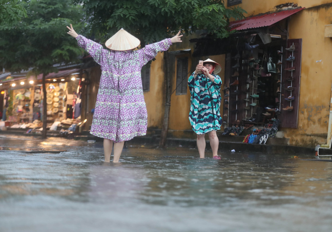 Khách nước ngoài bì bõm check-in giữa phố Hội ngập lũ