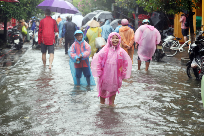 Khách nước ngoài bì bõm check-in giữa phố Hội ngập lũ