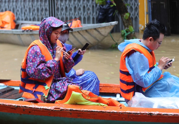 Khách nước ngoài bì bõm check-in giữa phố Hội ngập lũ