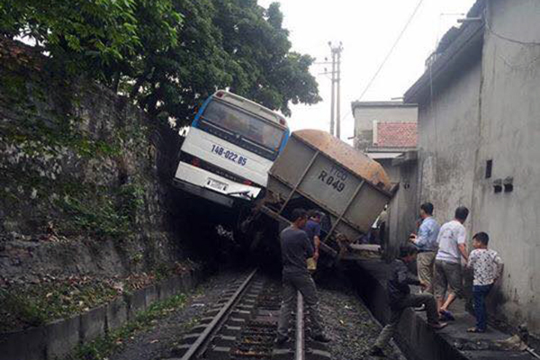 Tàu hỏa chèn xe khác chở công nhân lơ lửng trên sườn đồi