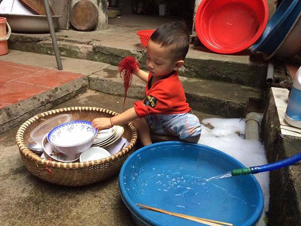 Thấy bố mẹ ăn xong không dọn, bé trai vừa rửa bát vừa nói câu khiến cả nhà đứng hình