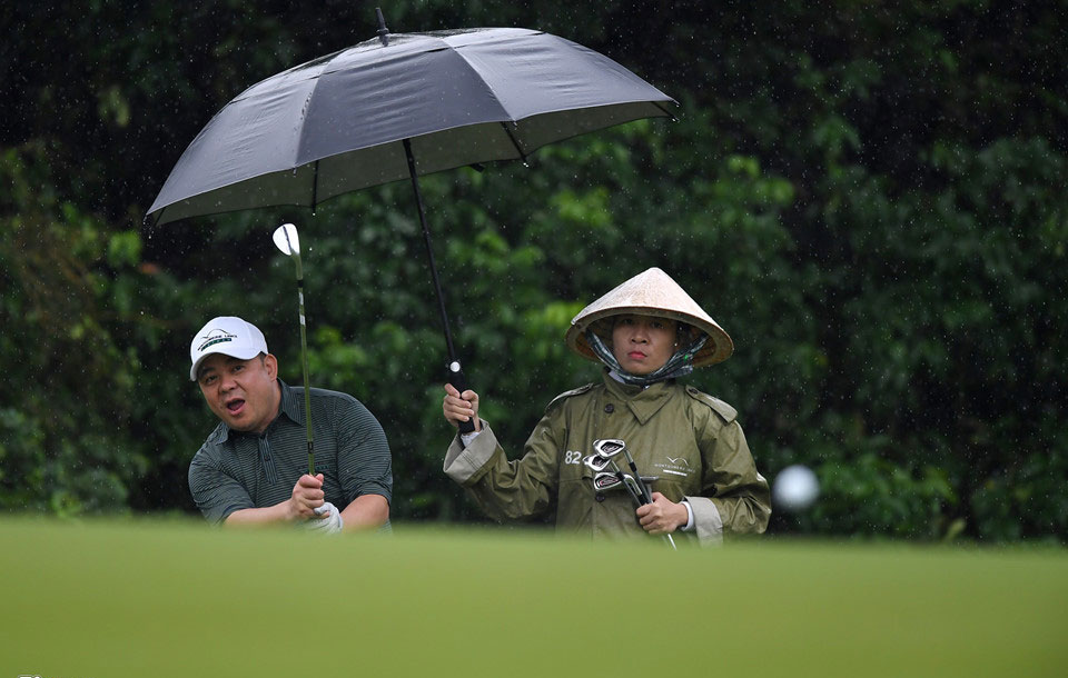 Hơn 100 CEO dự APEC đánh golf dưới mưa tầm tã ở Hội An