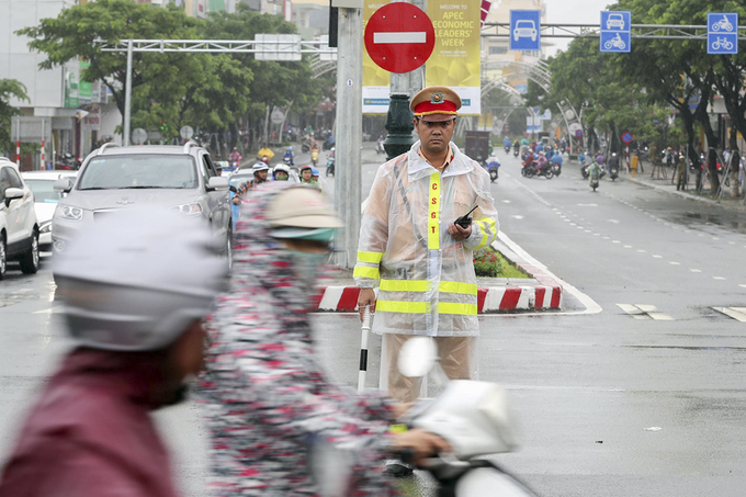 Cảnh sát phân luồng xe APEC dưới mưa