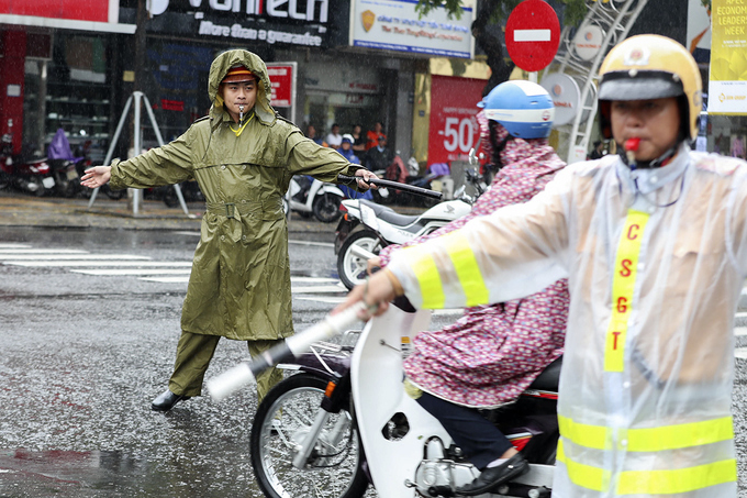 Cảnh sát phân luồng xe APEC dưới mưa