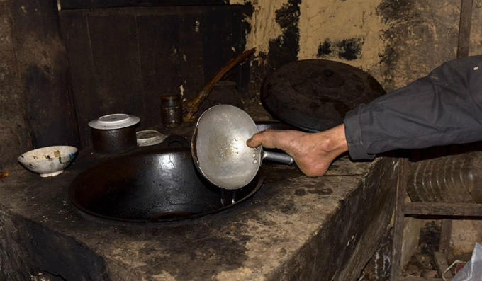 Con trai mất cả hai tay giữ thìa bằng răng để bón cơm cho mẹ