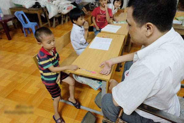 Thầy giáo viết chữ bằng miệng: Giờ đây con trai là đôi chân, đôi tay của tôi