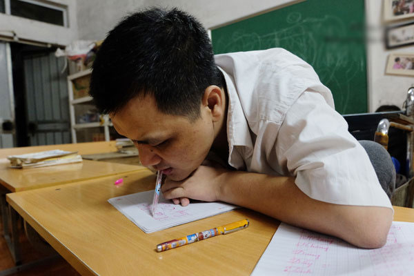 Thầy giáo viết chữ bằng miệng: Giờ đây con trai là đôi chân, đôi tay của tôi