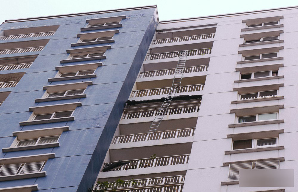 Người nhện leo chung cư Carina chùi rửa bức tường ám khói đen kịt sau vụ cháy khiến 13 người chết