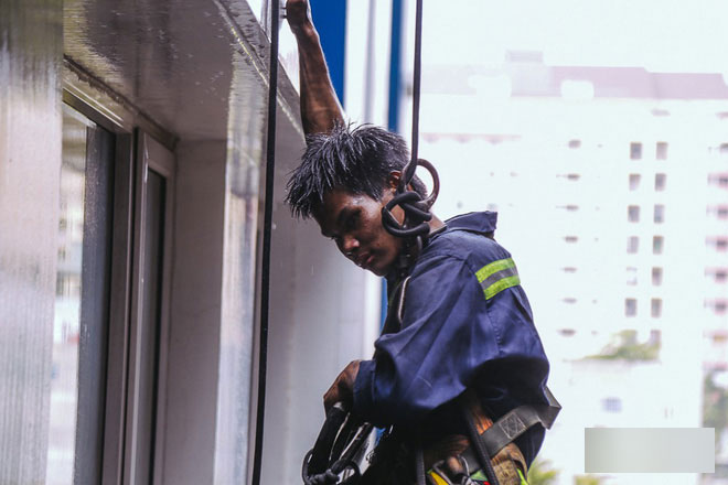 Người nhện leo chung cư Carina chùi rửa bức tường ám khói đen kịt sau vụ cháy khiến 13 người chết