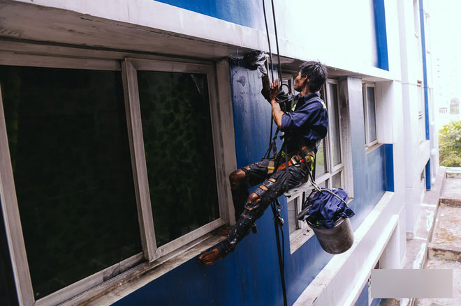 Người nhện leo chung cư Carina chùi rửa bức tường ám khói đen kịt sau vụ cháy khiến 13 người chết