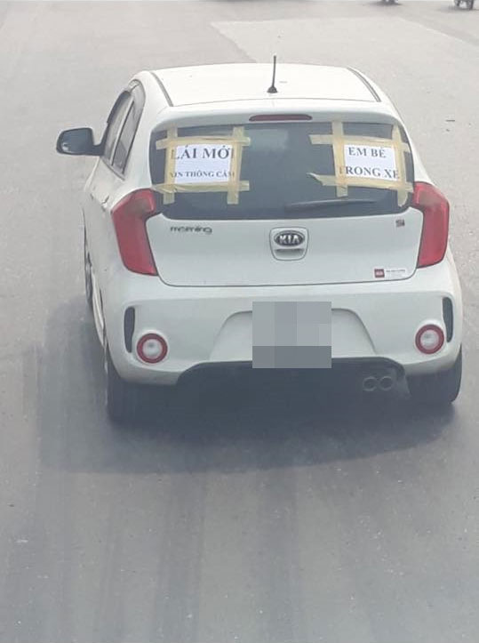 Tấm biển thông báo dán sau ô tô khiến người đi đường phải né tránh