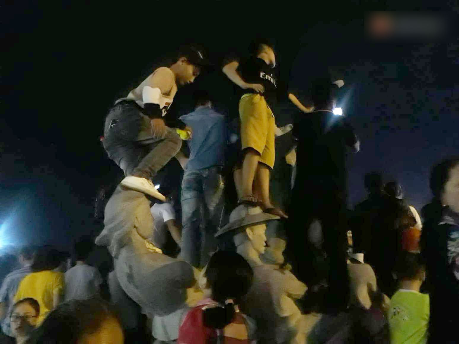 Ngán ngẩm hình ảnh hàng chục nam thanh niên giẫm đạp lên các bức tượng ở Cửa Lò để xem pháo hoa