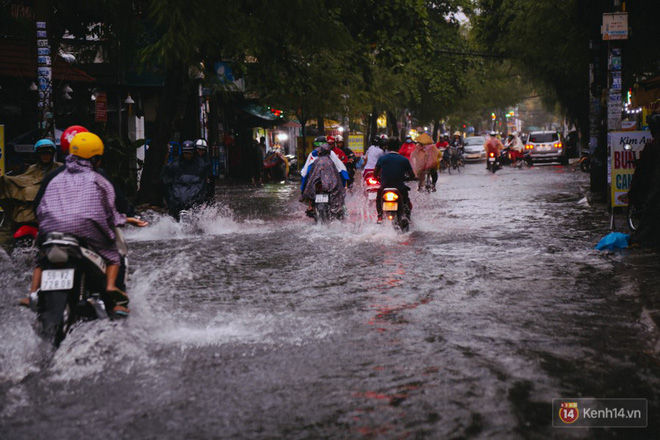 Phụ huynh ẵm bồng con nhỏ, bì bõm lội nước về nhà sau cơn mưa lớn ở Sài Gòn Phụ huynh ẵm bồng con nhỏ, bì bõm lội nước về nhà sau cơn mưa lớn ở Sài Gòn