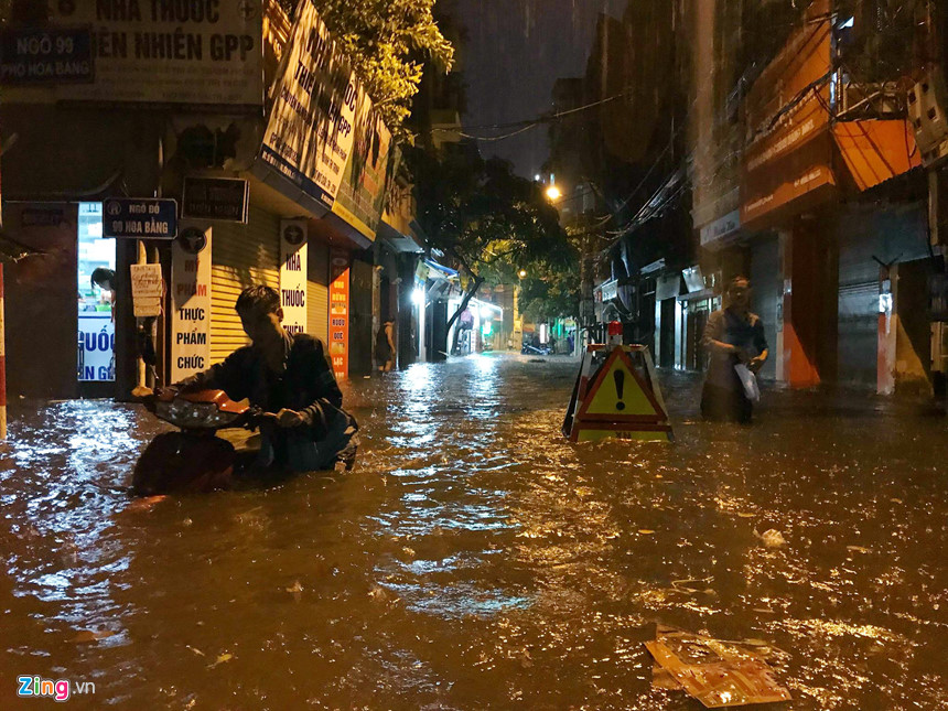 Mưa lớn trút xuống, người co chân ngồi nhậu, kẻ hì hục tát nước