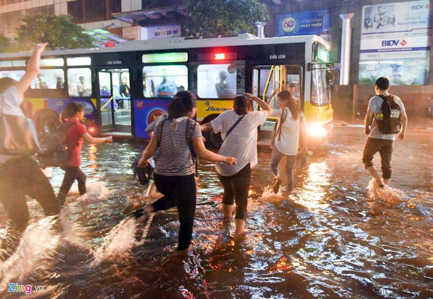 Mưa lớn trút xuống, người co chân ngồi nhậu, kẻ hì hục tát nước