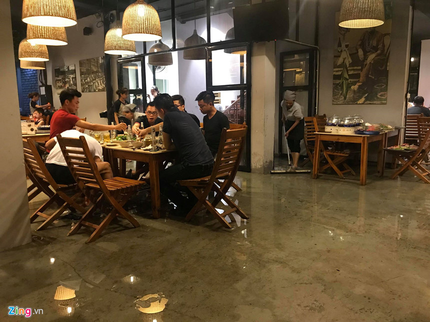 Mưa lớn trút xuống, người co chân ngồi nhậu, kẻ hì hục tát nước