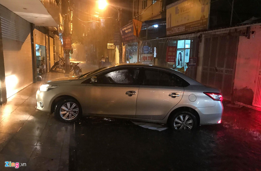 Mưa lớn trút xuống, người co chân ngồi nhậu, kẻ hì hục tát nước