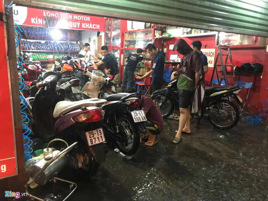 Mưa lớn trút xuống, người co chân ngồi nhậu, kẻ hì hục tát nước