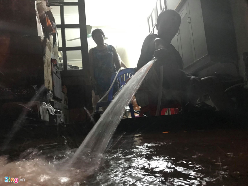 Mưa lớn trút xuống, người co chân ngồi nhậu, kẻ hì hục tát nước