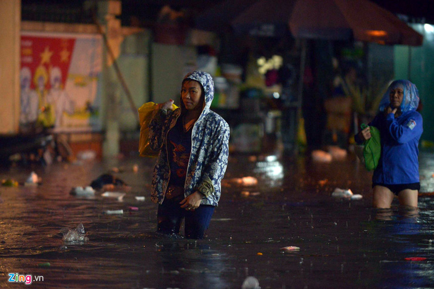 Mưa lớn trút xuống, người co chân ngồi nhậu, kẻ hì hục tát nước