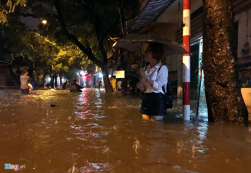 Mưa lớn trút xuống, người co chân ngồi nhậu, kẻ hì hục tát nước