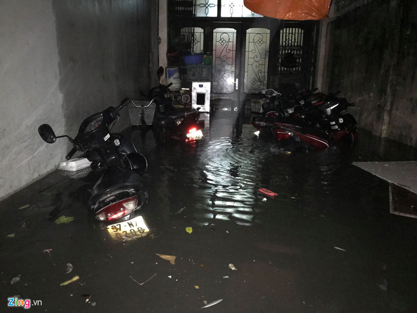 Mưa lớn trút xuống, người co chân ngồi nhậu, kẻ hì hục tát nước