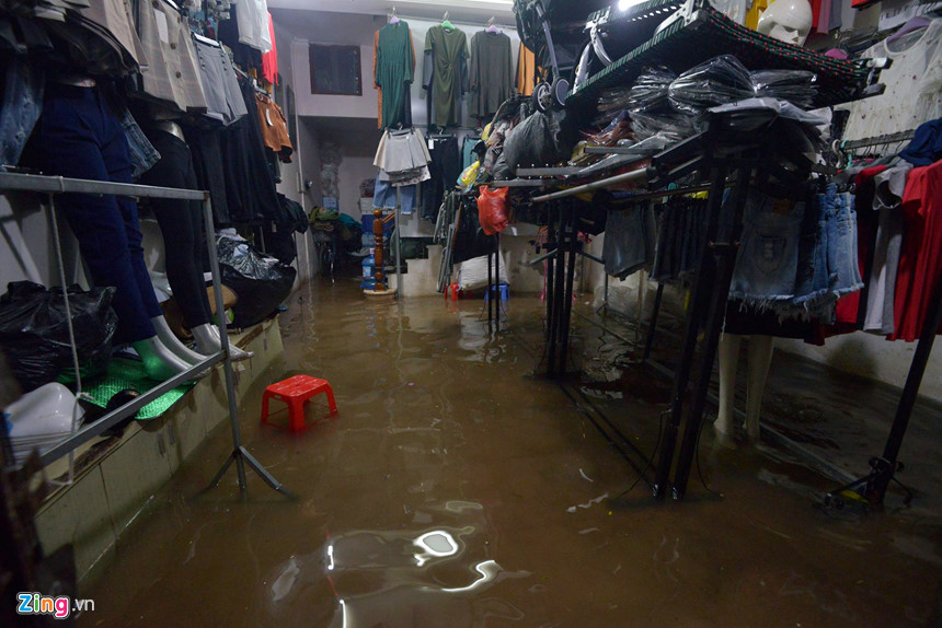 Mưa lớn trút xuống, người co chân ngồi nhậu, kẻ hì hục tát nước