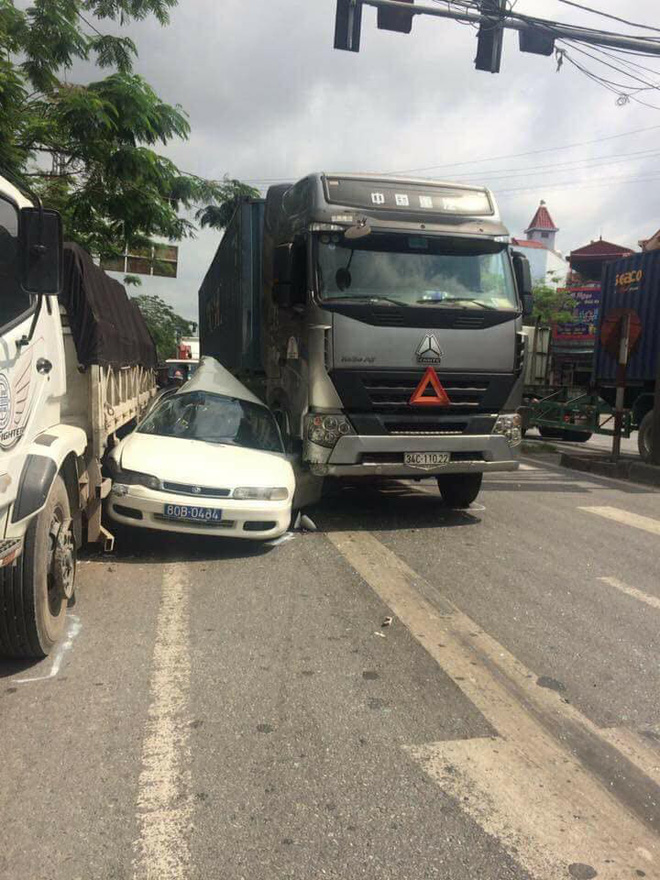 Ô tô biển xanh biến dạng khi bị kẹp giữa hai xe tải