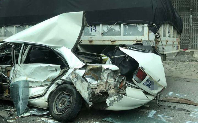 Ô tô biển xanh biến dạng khi bị kẹp giữa hai xe tải