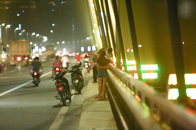 Người dân vô tư vượt lan can, đi ngược chiều để hóng mát trên cầu Nhật Tân Người dân vô tư vượt lan can, đi ngược chiều để hóng mát trên cầu Nhật Tân