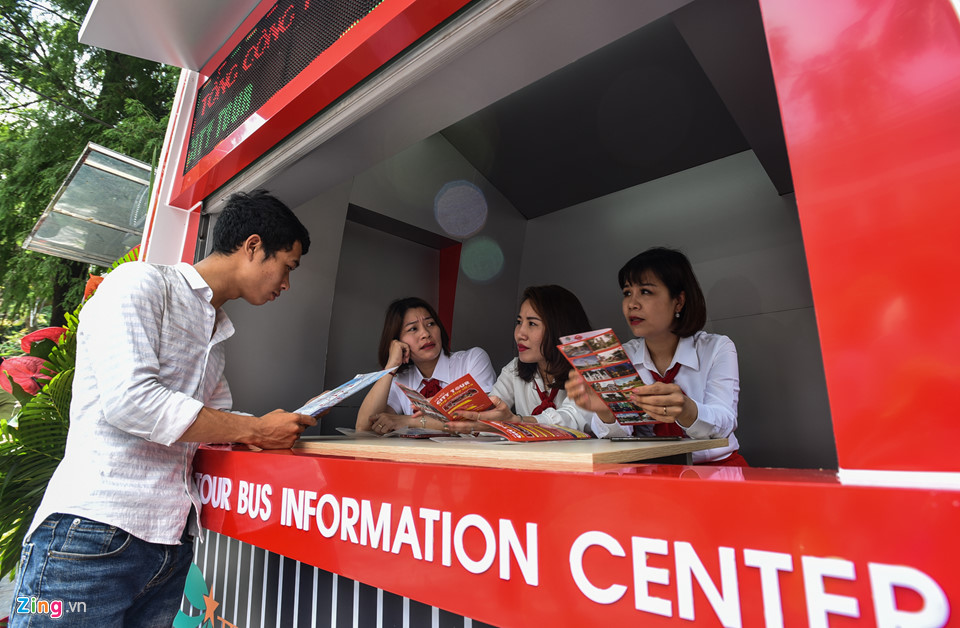 Khách dùng ô che nắng đi xe buýt hai tầng ở Hà Nội