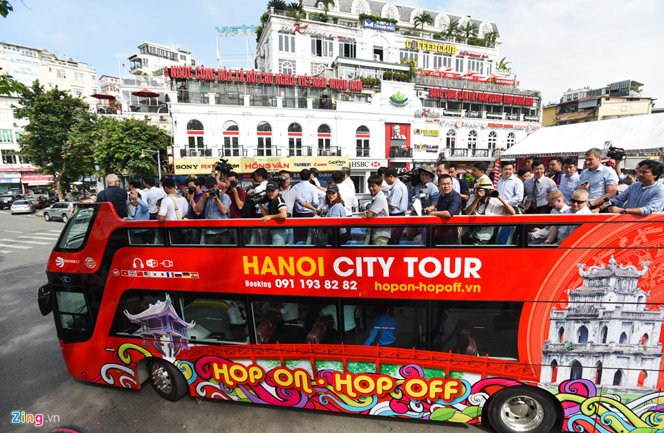 Khách dùng ô che nắng đi xe buýt hai tầng ở Hà Nội