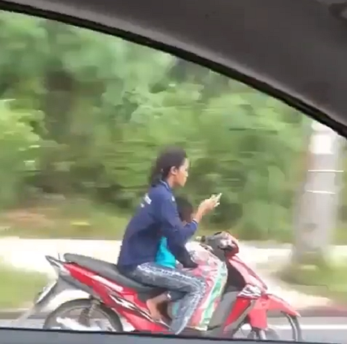 Sốc với clip nữ quái xế chở trẻ nhỏ vẫn vô tư lướt Facebook