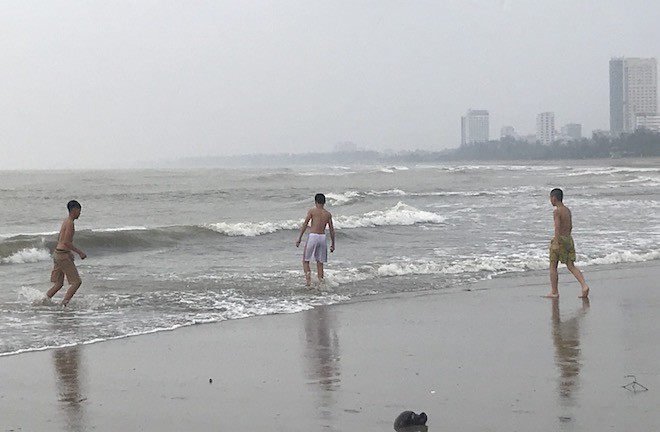Bất chấp bão Sơn Tinh đang tiến vào, du khách vẫn xuống biển Cửa Lò tắm trong mưa