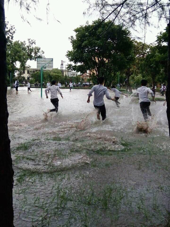 Chùm ảnh: Học sinh, sinh viên thích thú tắm mưa, tạt nước tưng bừng khi sân trường ngập lụt
