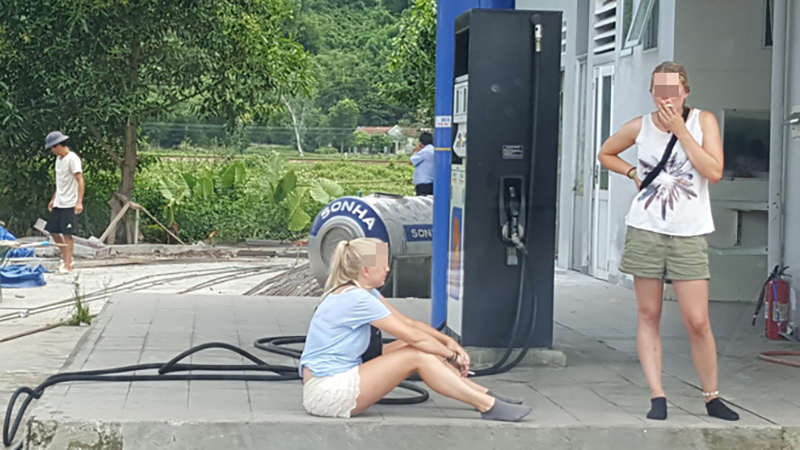 Hình ảnh hai cô gái ngoại quốc vô tư ngồi hút thuốc cạnh cây xăng gây tranh cãi