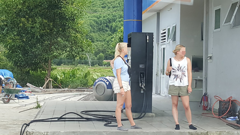 Hình ảnh hai cô gái ngoại quốc vô tư ngồi hút thuốc cạnh cây xăng gây tranh cãi