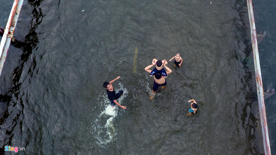Trai tráng trêu đùa xe cộ đang cố băng qua đường ngập nước