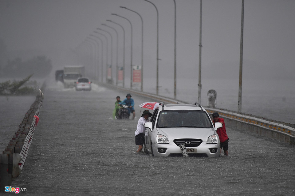 Trai tráng trêu đùa xe cộ đang cố băng qua đường ngập nước