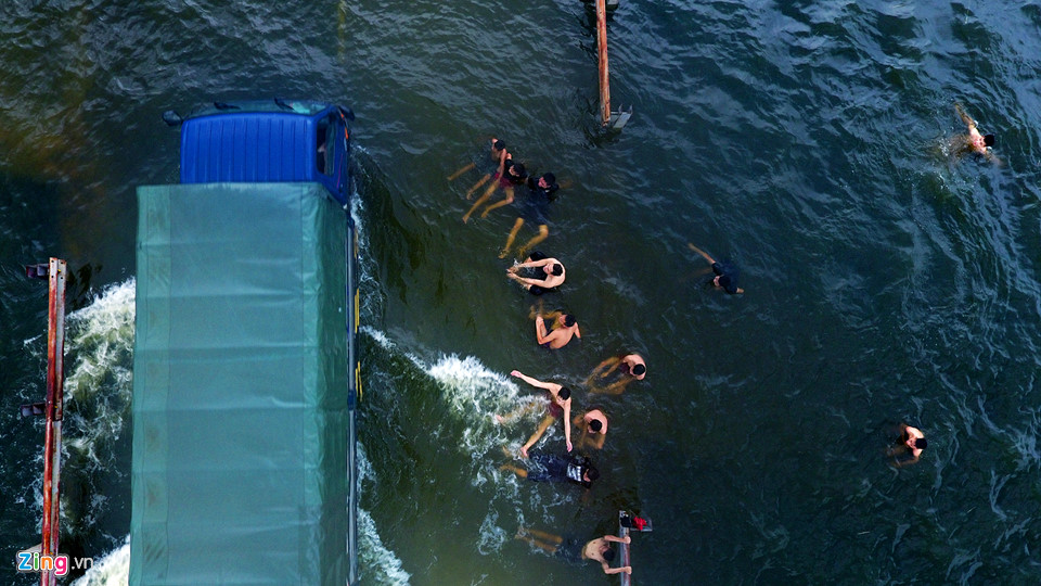 Trai tráng trêu đùa xe cộ đang cố băng qua đường ngập nước