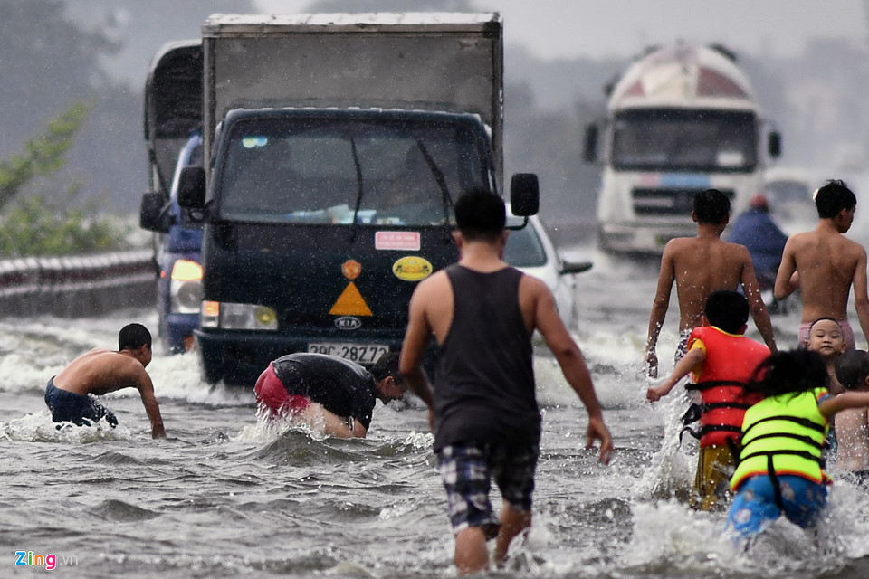 Trai tráng trêu đùa xe cộ đang cố băng qua đường ngập nước