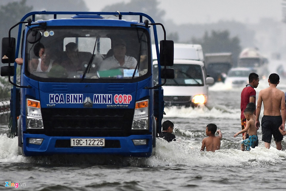 Trai tráng trêu đùa xe cộ đang cố băng qua đường ngập nước