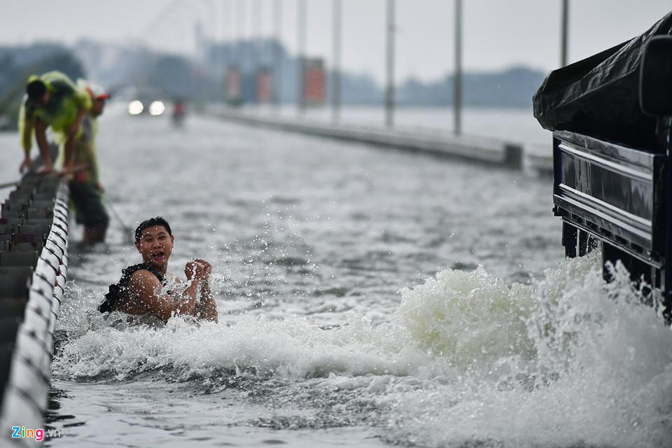 Trai tráng trêu đùa xe cộ đang cố băng qua đường ngập nước