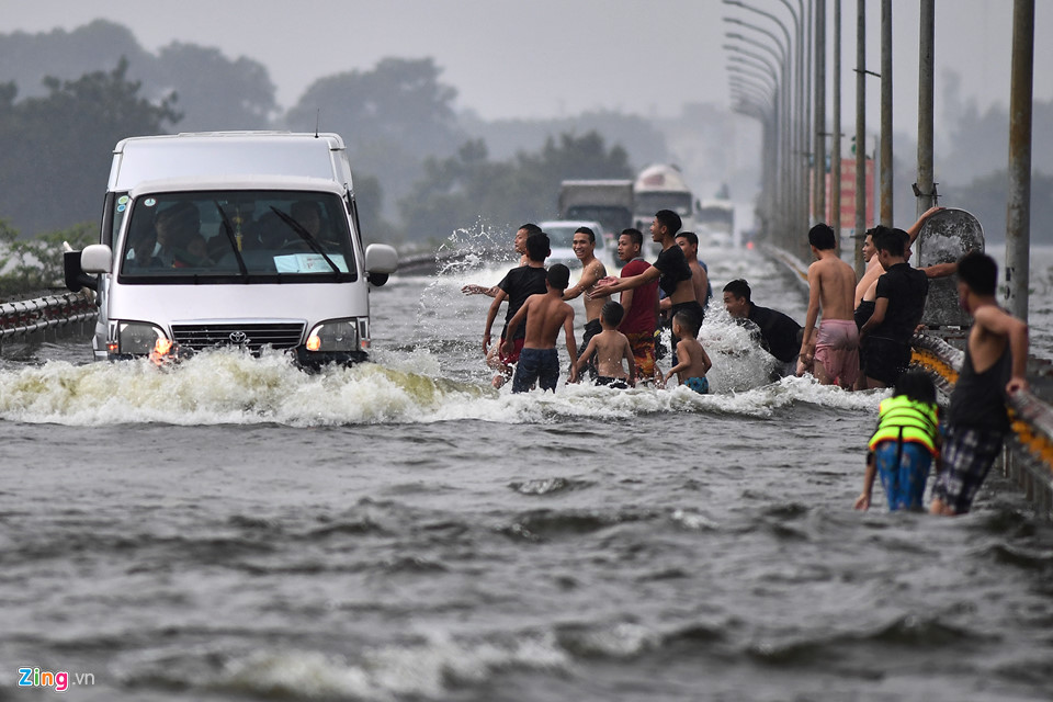 Trai tráng trêu đùa xe cộ đang cố băng qua đường ngập nước