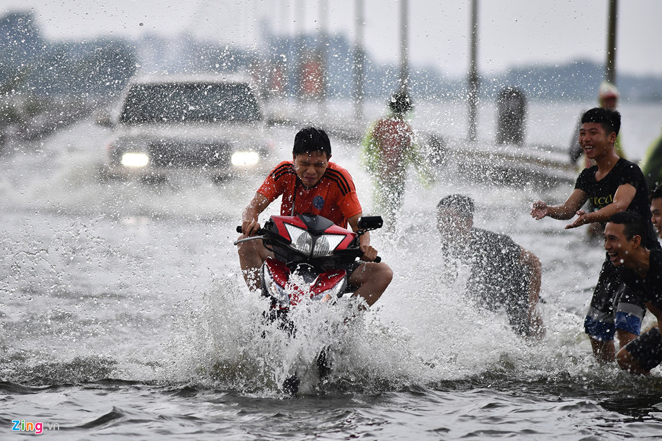 Trai tráng trêu đùa xe cộ đang cố băng qua đường ngập nước