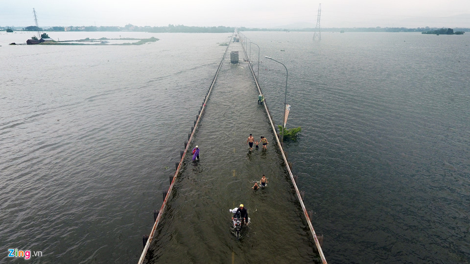 Trai tráng trêu đùa xe cộ đang cố băng qua đường ngập nước