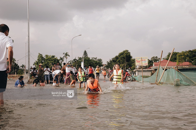 Video: Nước vừa rút lại lên, người già trẻ nhỏ tiếp tục ùa ra đường tỉnh lộ vô tư bơi lội khi phương tiện bị cấm lưu thông