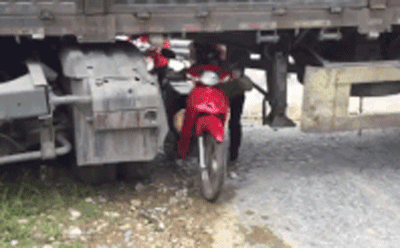 Ôtô đầu kéo mắc kẹt ngang đường, dân chui qua gầm để di chuyển Ôtô đầu kéo mắc kẹt ngang đường, dân chui qua gầm để di chuyển